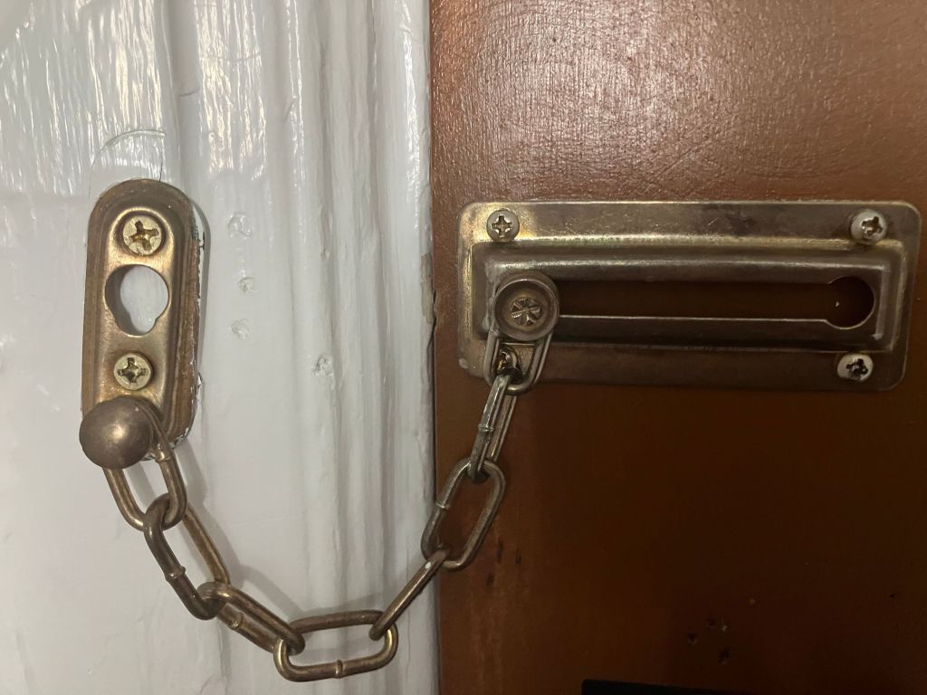 Brass door chain on a hotel room door