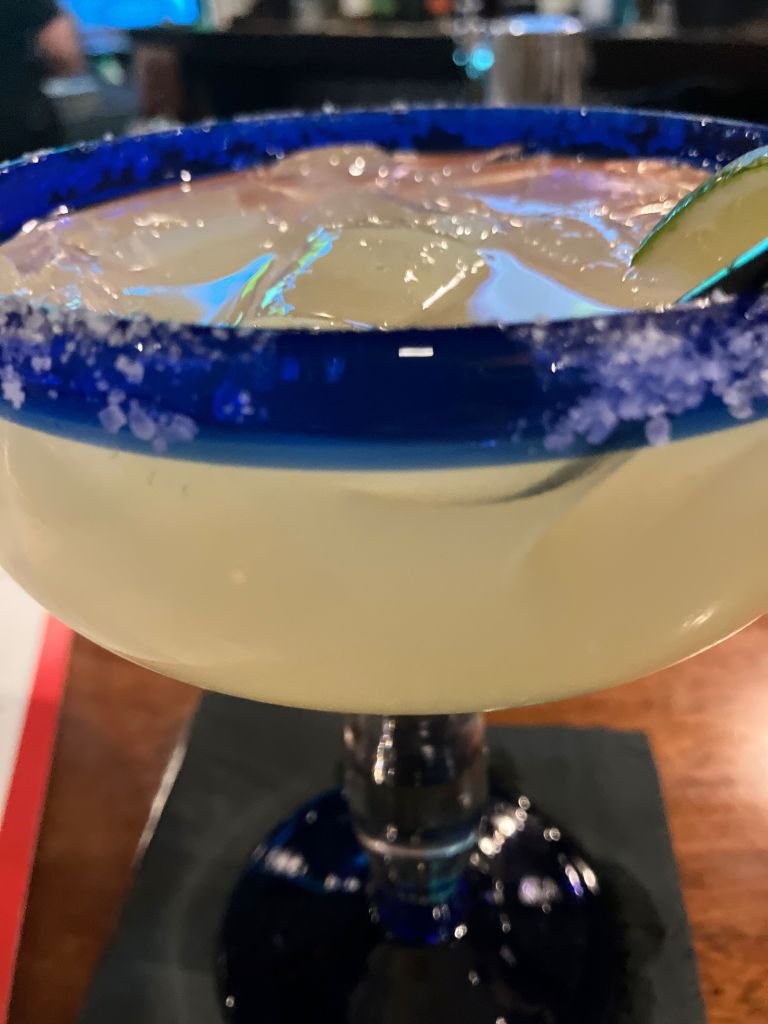 Margarita with a salted rim in a cobalt blue glass
