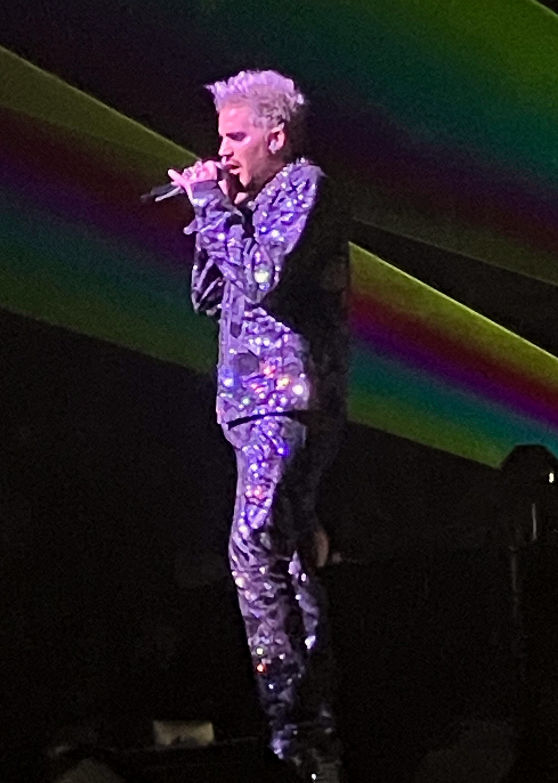 Adam Lambert singing in a sequined suit