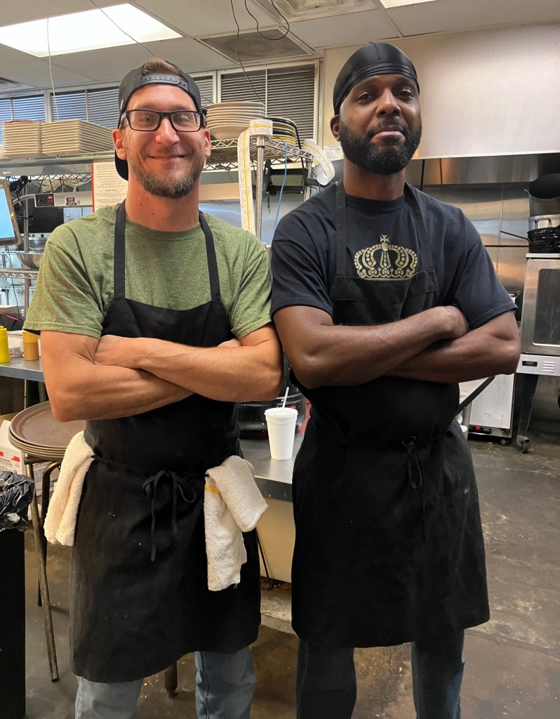 Chefs Ryan and Bernard standing in the kitchen with arms crossed