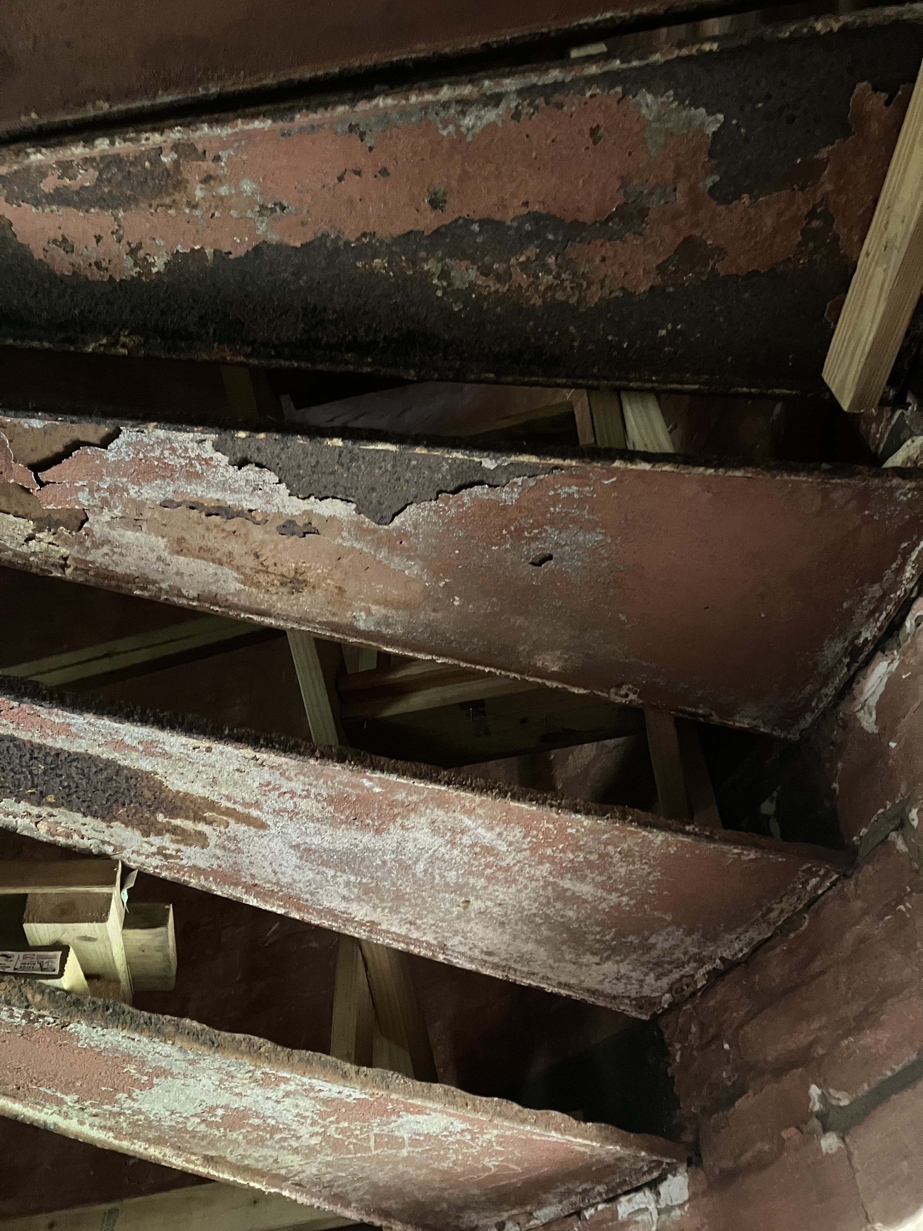 Rusted iron stair treads seen from below