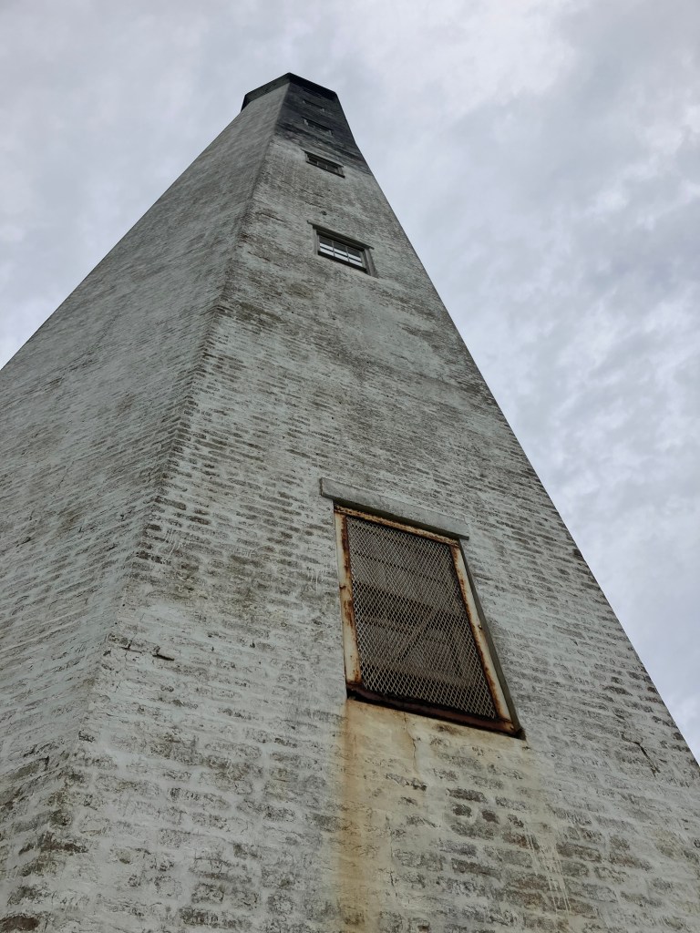 Weathered brick and a window on the lighthouse tower