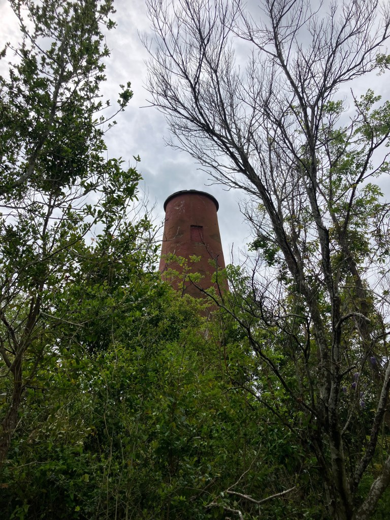 The older 1827 brick lighthouse tower seen through the trees