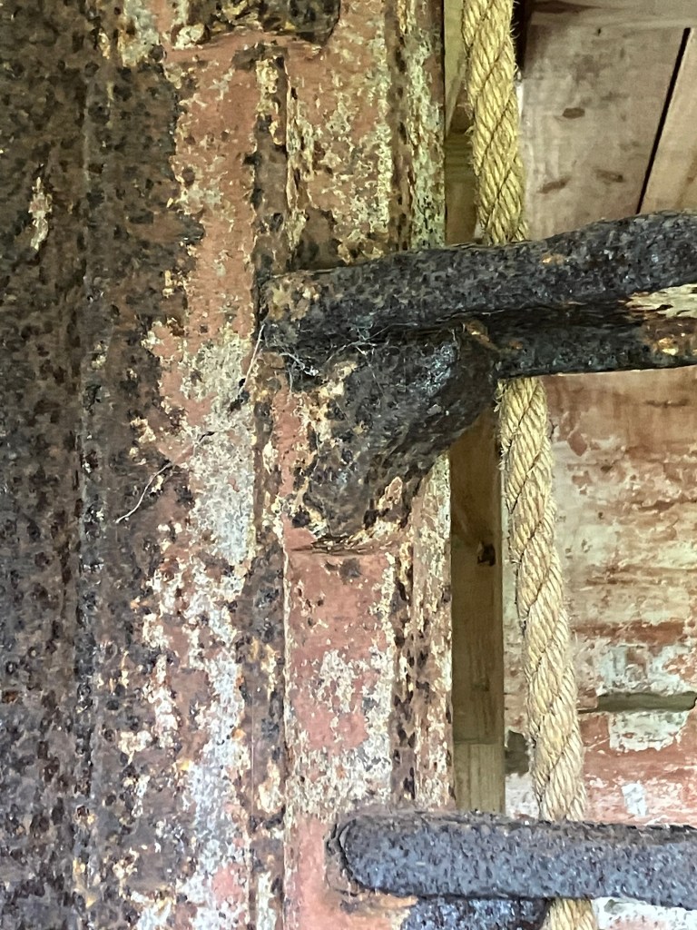 Rusted iron stair bracket against the wall