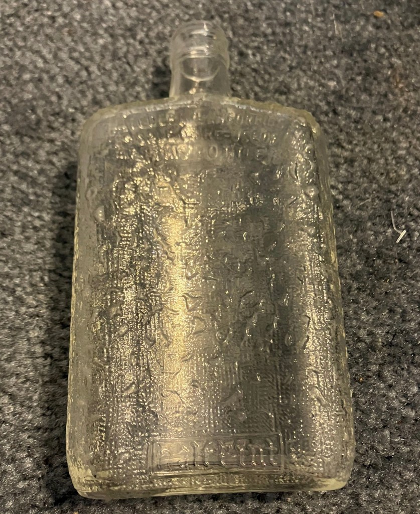 The glass flask lying flat, showing its textured pattern