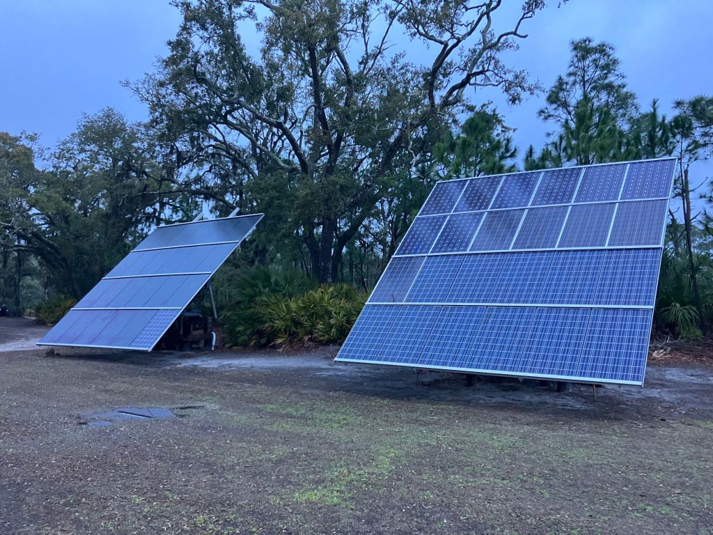 Solar panel arrays in a clearing on the island