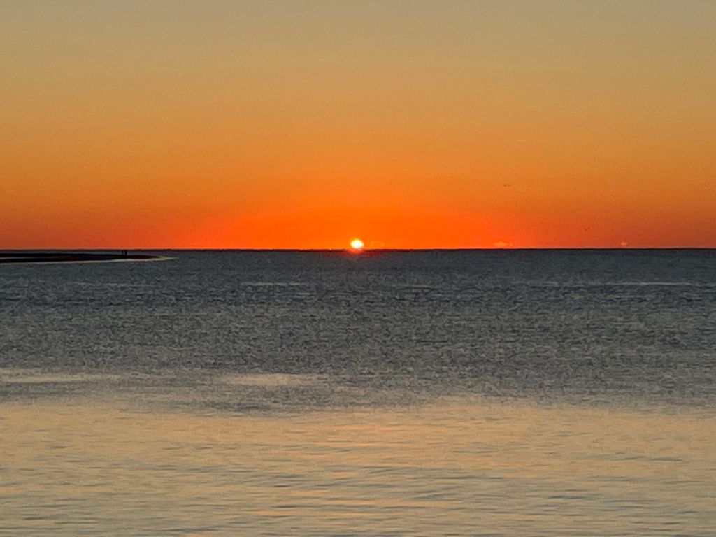 Sun setting on the horizon over the water