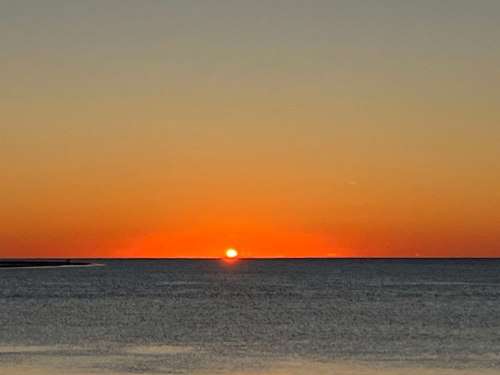 Last orange light of sunset over the water