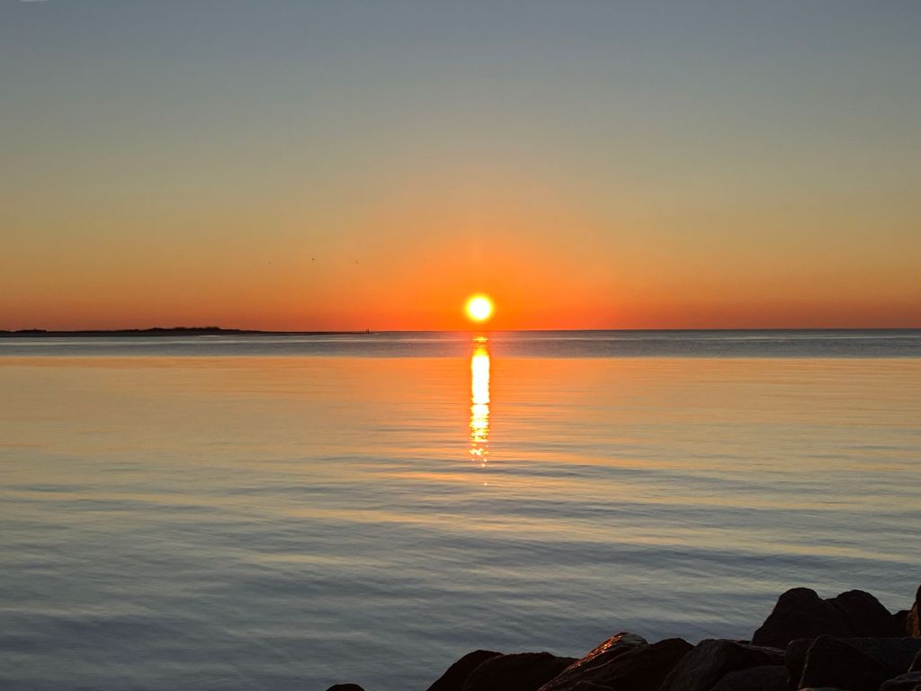 Sun on the horizon with a reflection on the water