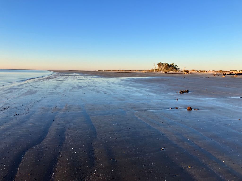 Rippled sand at the water's edge with the island beyond