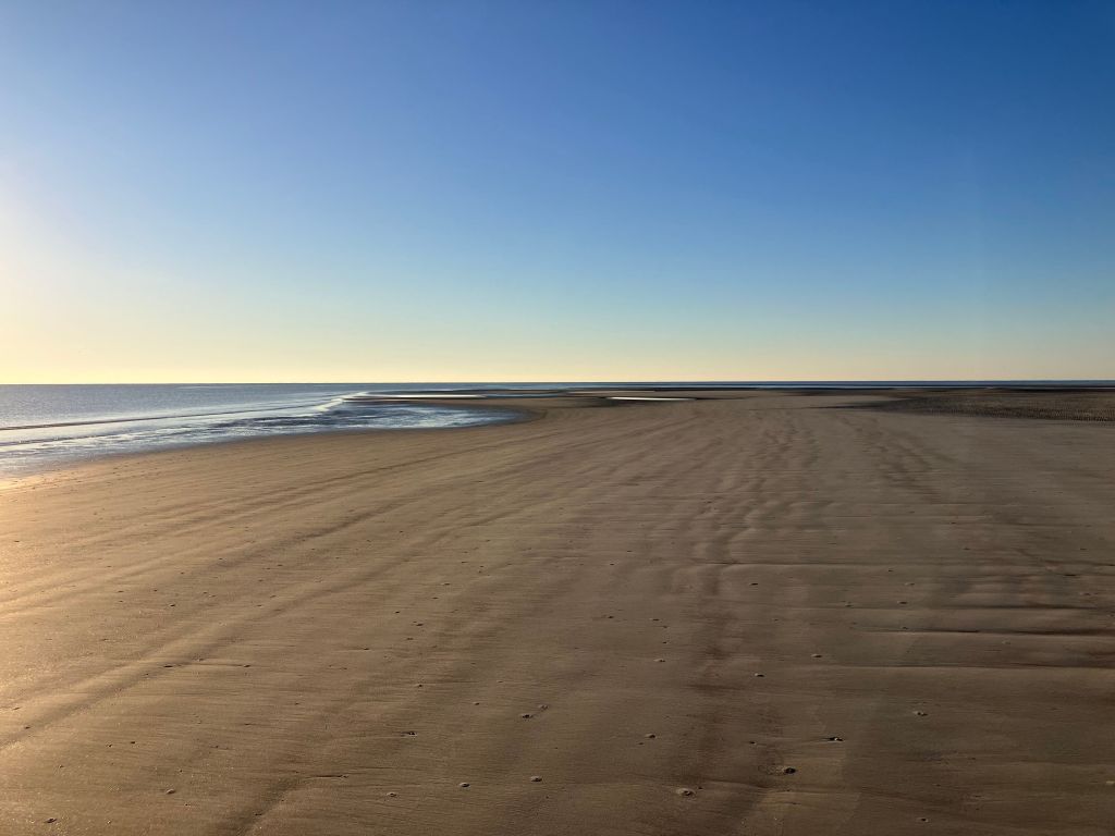 Long empty beach in early morning light
