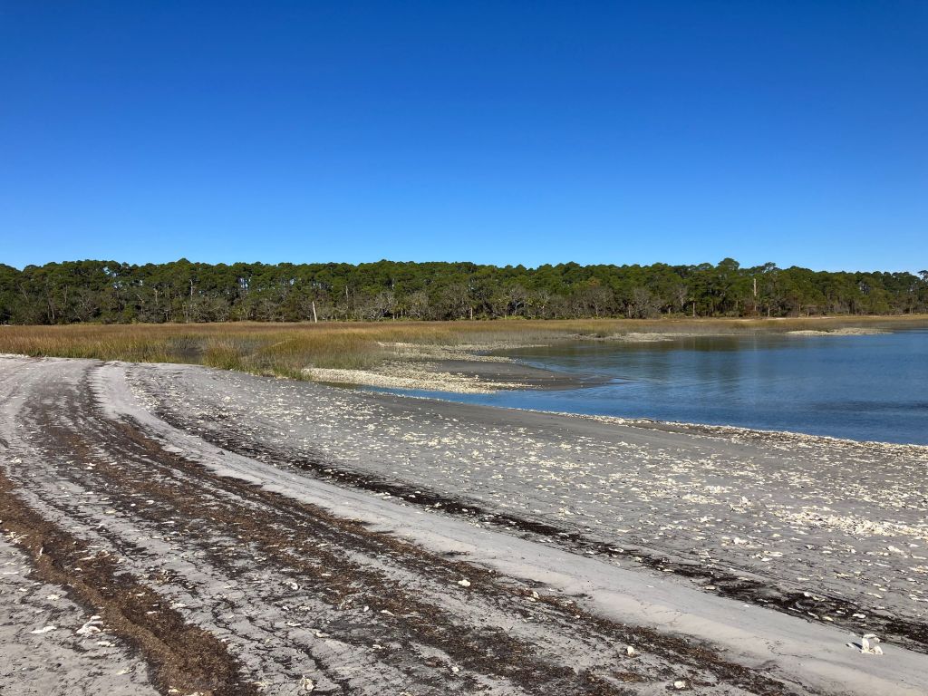 Tire tracks on the sand at North Beach with the water beyond