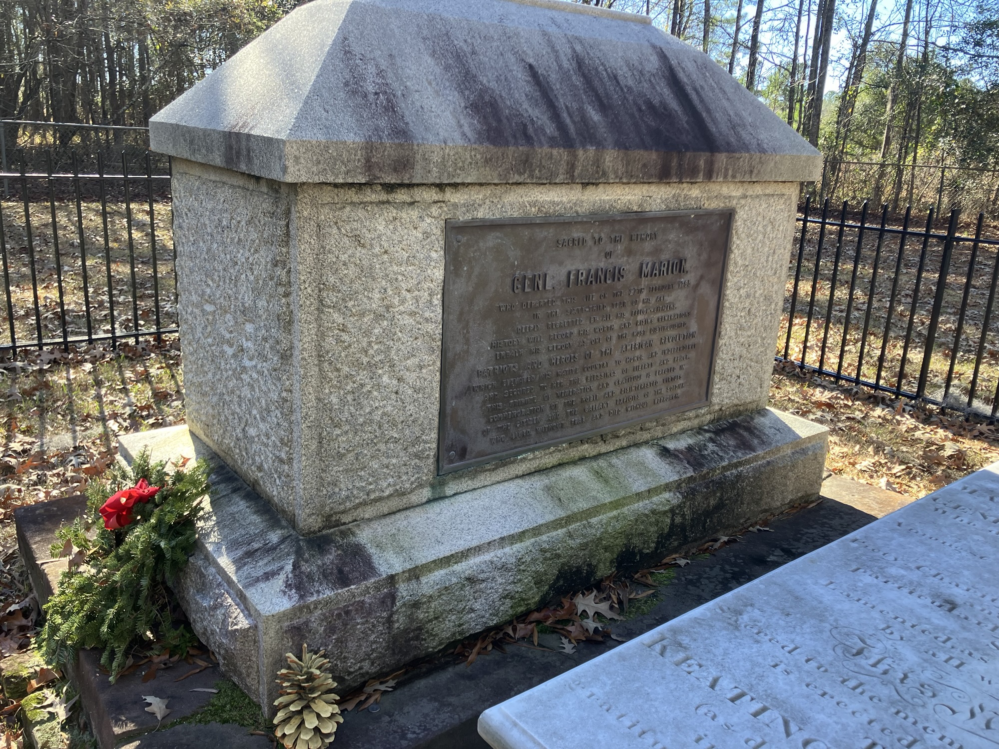Francis Marion's stone tomb with wreaths inside the iron fence