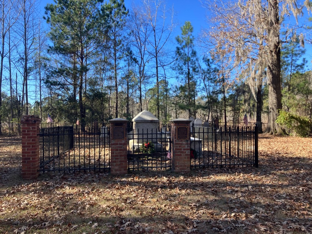 The fenced Marion family graveyard among the trees at Belle Isle