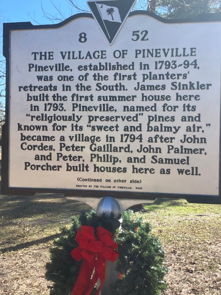 Historical marker 8-52, The Village of Pineville, established in 1793–94, with a wreath at its base