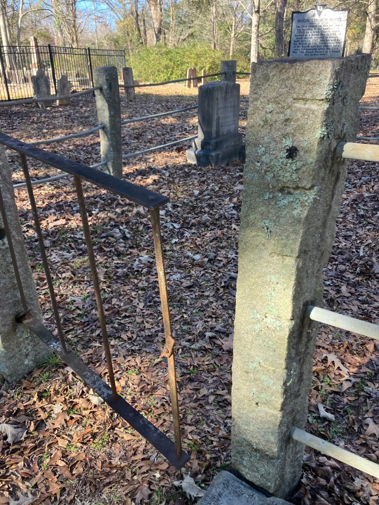 Old gravestones and an iron fence in the Biggin Church churchyard