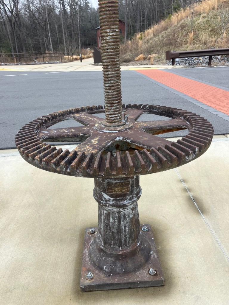 Old geared valve wheel on an iron stand at the access area